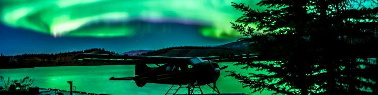 Aurora takes up the night sky above a lake.